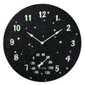Round black galaxy clock with glowing green numbers and stars and a thermometer gauge at the bottom
