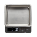 Close up of a Taylor 22 lb kitchen scale with a stainless steel storage container and lid.