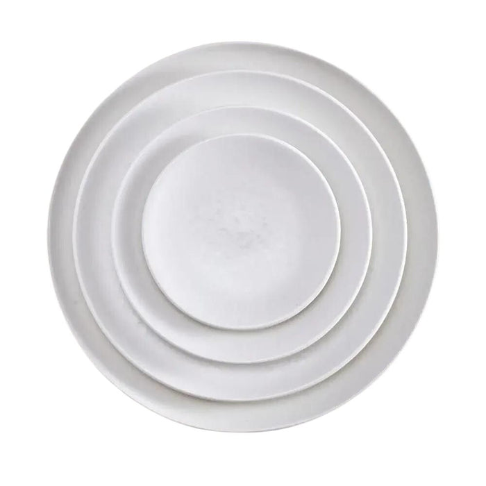 Four white, round Alchimie Dinnerware plates by L'Objet are stacked neatly inside one another, viewed from above on a plain white background—luxurious tableware ideal for any refined setting.