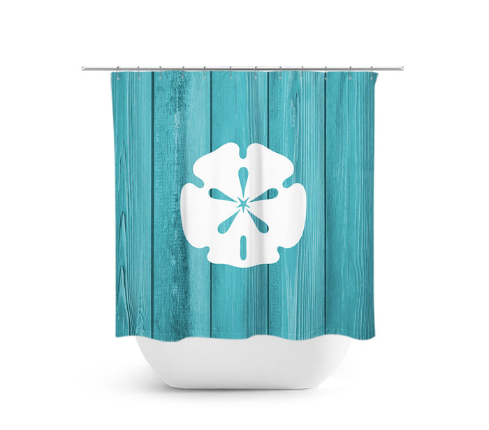 A shower curtain featuring a central white sand dollar design against a teal colored background of wood planks.