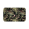 A rectangular memory foam mat with a black and green floral pattern on it.