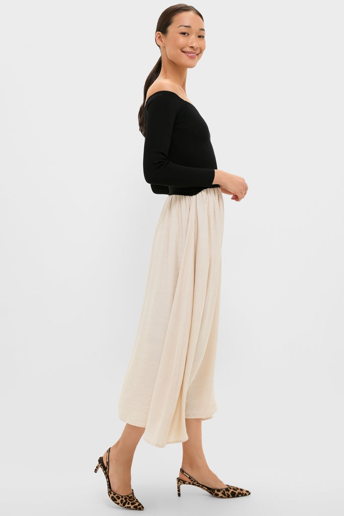Model in a Black and Ivory Off Shoulder Maxi Dress with a classic, effortless style; featuring a fitted bodice and flowing A-line skirt, embodying high-end elegance.
