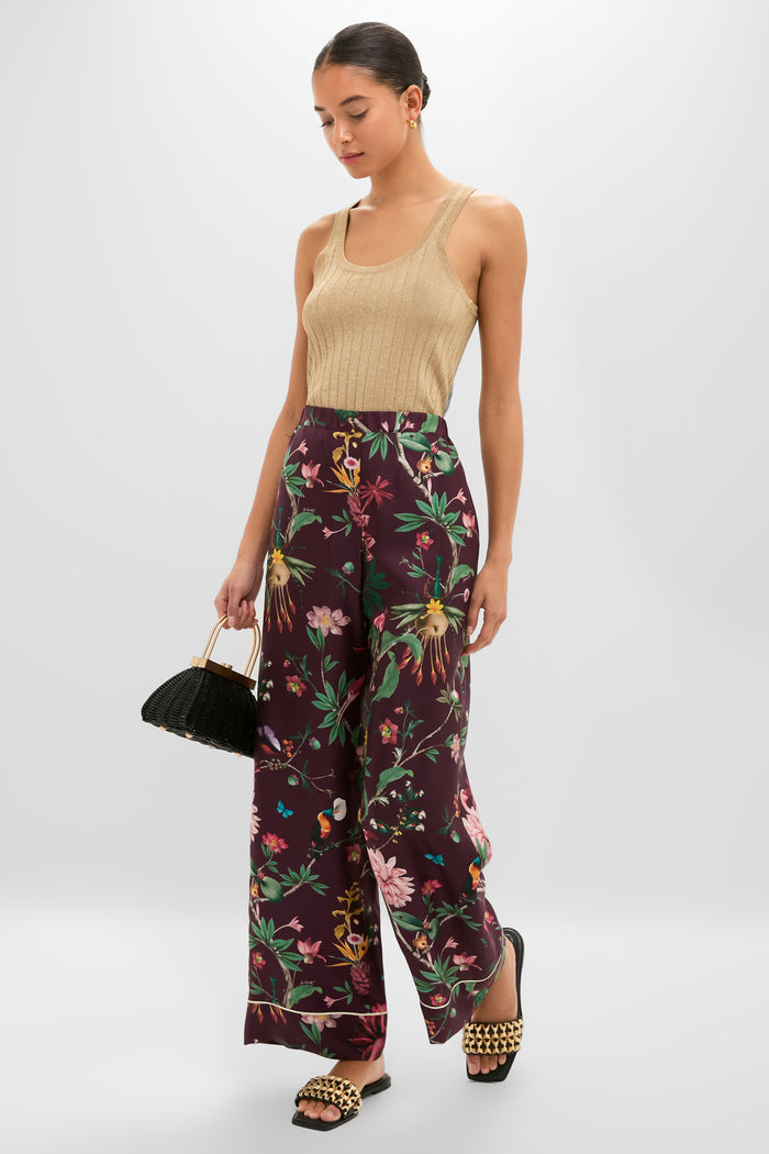 Model showcases Black Faye Beaded Leather Flat Slides with gold-tone studs, embodying classic and effortless style. Paired with chic, high-waisted floral trousers for a fun, high-end look.