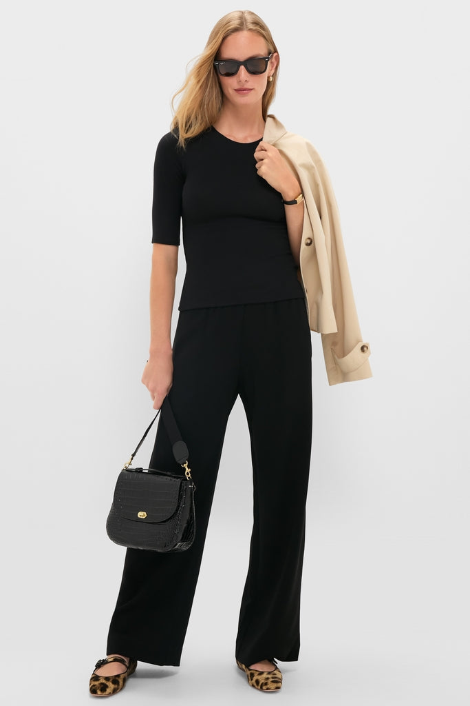 Model wearing the classic Black Lauren Mid Sleeve Tee with wide-leg trousers and leopard-print flats, exuding an effortless, high-end style.