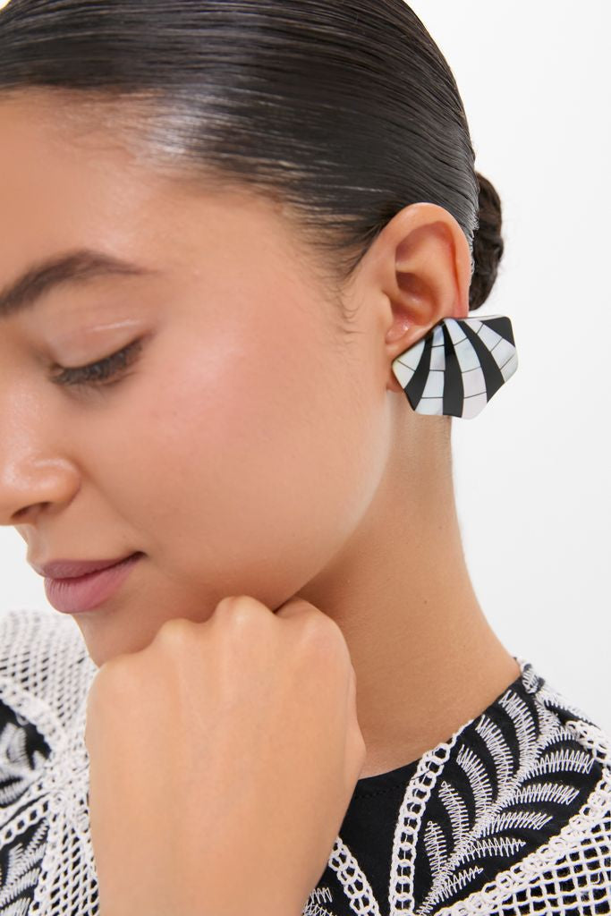 Side-profile of a woman wearing Black Maris Earrings: classic, fan-shaped studs with a black and white optical pattern, adding an effortless, high-end touch to her fun, elegant style.