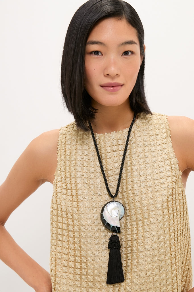 Young woman wearing the Black Nautilus Necklace, featuring a classic shell-inspired pendant and tassel, exuding effortless elegance and high-end style.