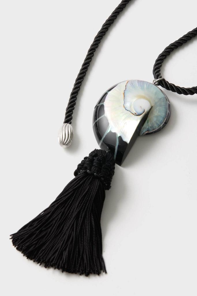 Black Nautilus Necklace features a classic spiral shell-like pendant on a twisted cord with tassel, blending effortless elegance with a fun, high-end design.