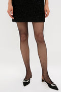 Classic Black Twenties Econyl Tights paired with a chic, textured skirt and stylish slingback flats, embodying an effortless and high-end look for any occasion.