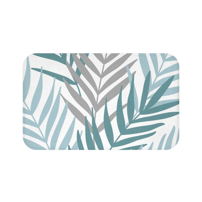 A rectangular memory foam mat with a printed design of palm leaves in shades of blue and gray on a white background.