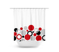 A shower curtain with a geometric pattern featuring red circles, black circles, and gray circles on a white background. The circles are like a geometric bubble bath.