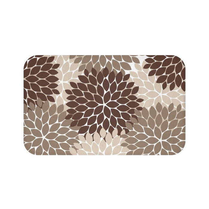 A rectangular memory foam mat with an abstract, brown, beige, and light brown floral burst pattern against a white background, and with an anti-slip backing.