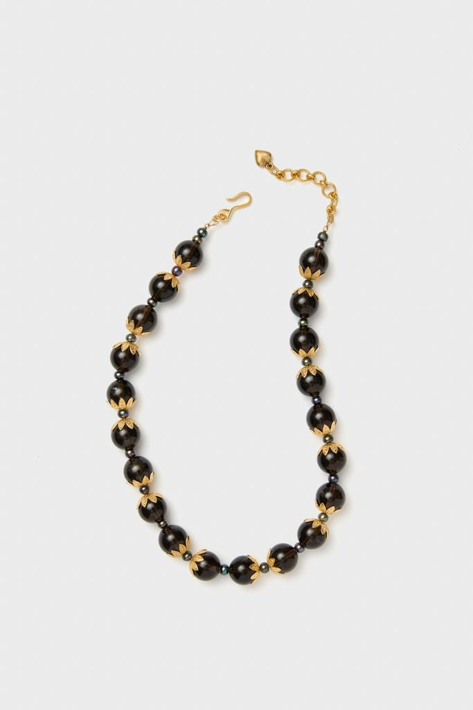 Brown Tommie Necklace: A classic, high-end accessory with polished dark beads framed by gold-tone caps, featuring an adjustable chain for effortless, fun style.