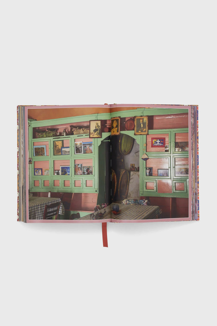 Cabana Anthology: The Anniversary Edition, featuring a vibrant café scene with green shutters and checkered tables, exudes classic, high-end design. Perfect for effortless, fun decor inspiration.