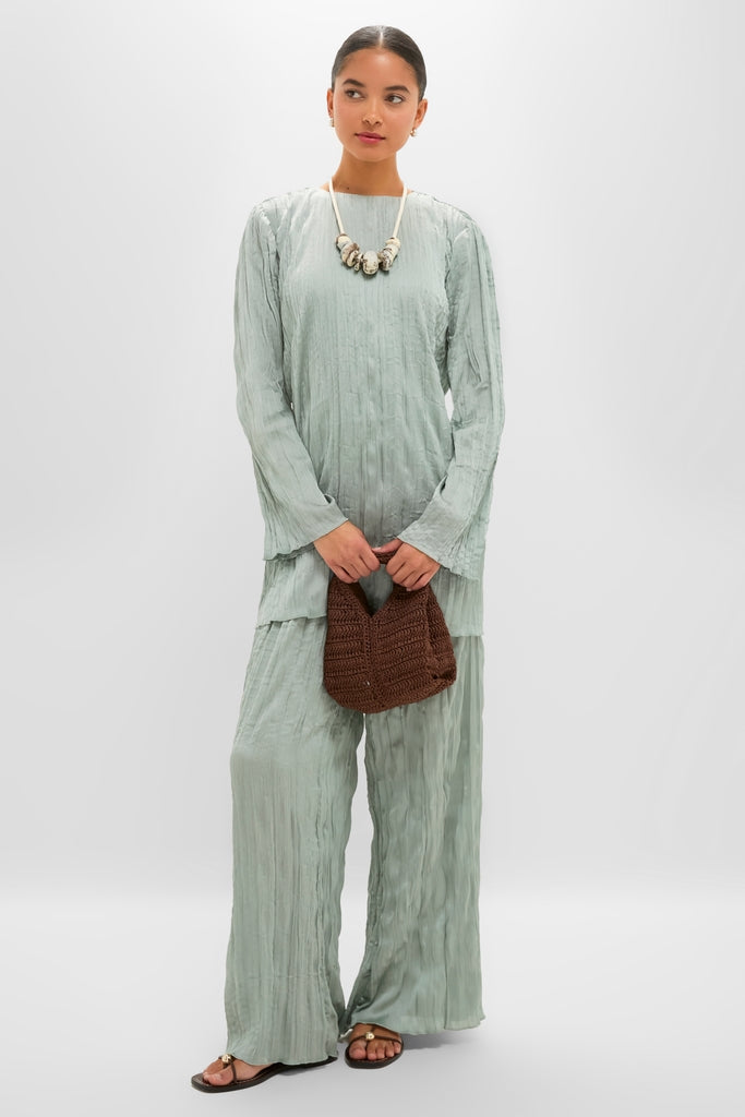 Woman in crinkled sage green outfit showcasing the Cappuccino Drift Choker; a classic, high-end piece with chunky beads, exuding effortless style and fun elegance.