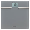 Charcoal gray body composition scale with digital readout showing 126.4 lb and two silver metal bars across front