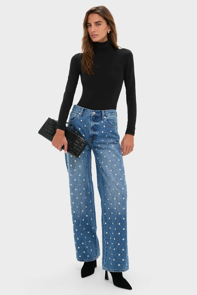 Model wearing classic Charmed Hendrix High Rise Baggy jeans with crystal embellishments, styled with a black turtleneck and clutch, exuding effortless fun and high-end appeal.