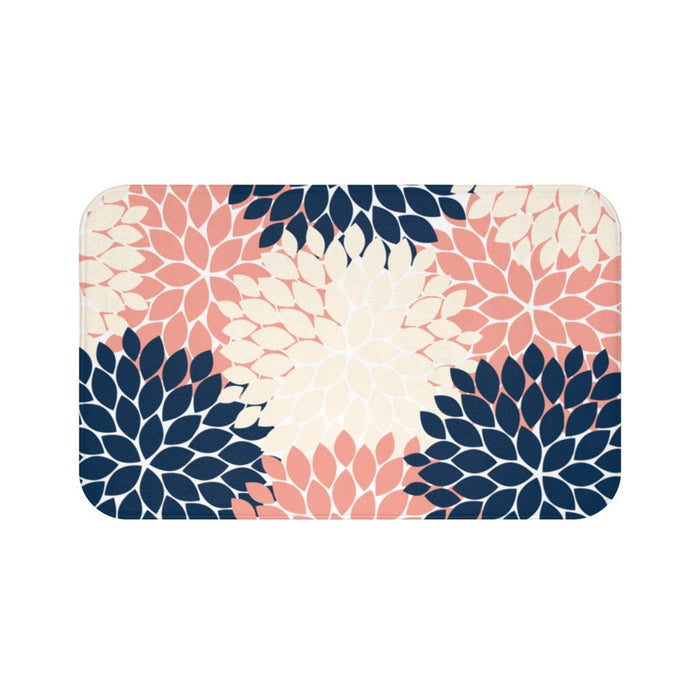A memory foam mat with a flower petal burst pattern and multiple flowers in navy blue, sand, and coral.