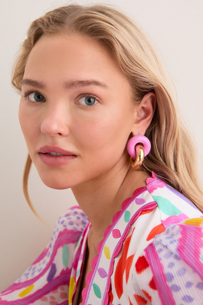 Young woman with blonde hair wearing classic, fun Cotton Candy and Gold Cumulus Earrings, featuring chunky gold hoops and pink elements, showcasing an effortless, high-end style.