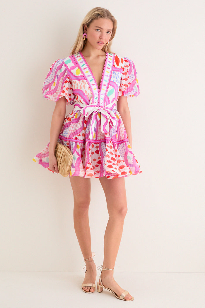 Young woman in a classic, effortless summer dress with Cotton Candy and Gold Cumulus Earrings, holding a woven clutch, embodying a fun, high-end style.
