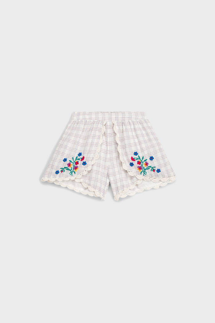 Cream Cruise Checks Asya Shorts feature classic scalloped lace hems, effortless floral embroidery, and fun overlapping panels, offering high-end boho style for warm weather adventures.