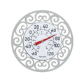 Decorative round metal frame with ornate scrollwork encasing a Taylor thermometer dial