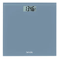 Slate blue digital glass scale on a wooden floor displaying 134.6 lb.