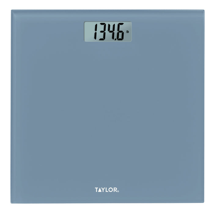 Slate blue digital glass scale on a wooden floor displaying 134.6 lb.