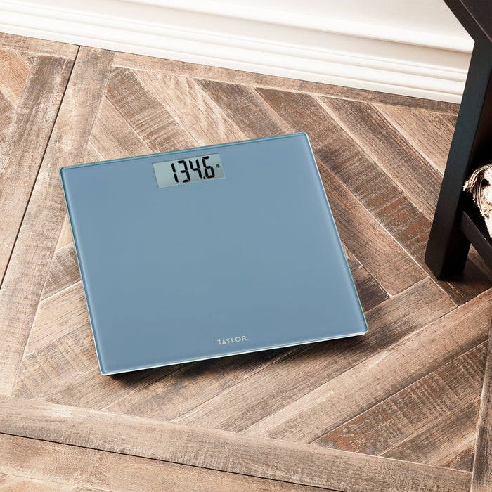 Slate blue digital glass scale on a wooden floor with Taylor logo visible.