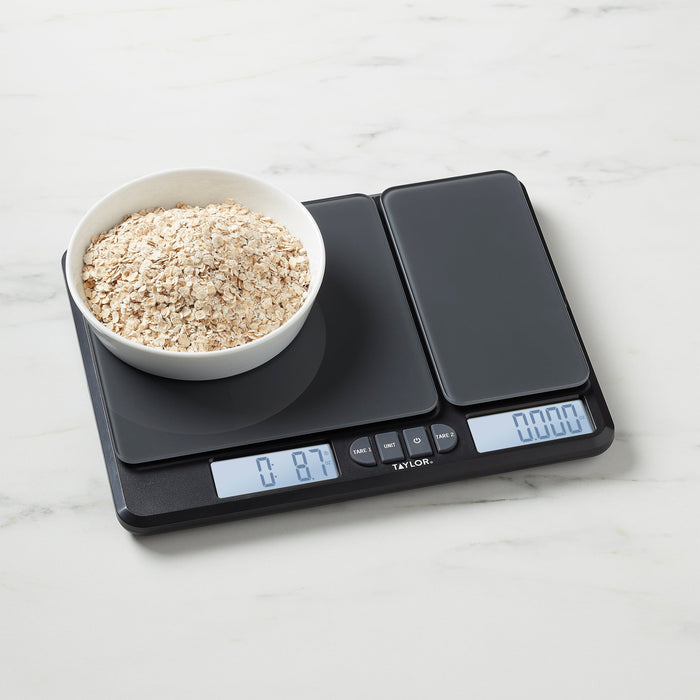 Taylor Dual Platform Kitchen Scale on marble counter with a bowl of oats on the left platform and blueberries nearby