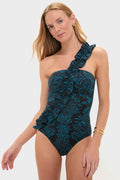 Model wearing the Eclipse Flora Capri Maillot, a classic, one-shoulder swimsuit with a teal floral pattern and ruffle detail, paired with gold hoop earrings for an effortlessly high-end look.