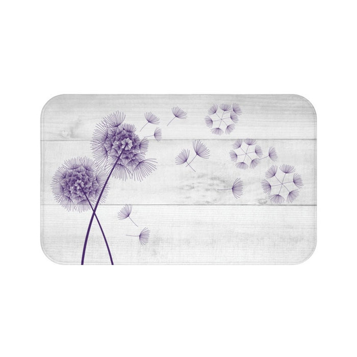 This is an image of a rectangular floor mat with rounded corners. The background of the mat mimics distressed, light gray wooden planks. The horizontal plank lines give the mat a texture and farmhouse feel. The primary graphic is a cluster of stylized dandelion seed heads (in purple) on the left side. The seed heads are drawn in fine detail, and several dandelion seeds are shown floating across, suggesting a gentle breeze.