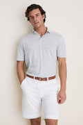 Male model wears the Gale Gray Linen Sanibel Polo, a classic, effortless piece with a partial button placket, paired with white tailored shorts and a brown belt.