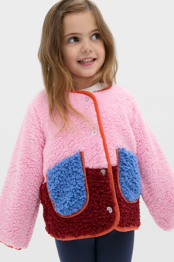 Young girl in a classic, fun, and cozy Girls Ruth Jacket, featuring effortless color-blocking and contrast piping, perfect for high-end style and warmth.