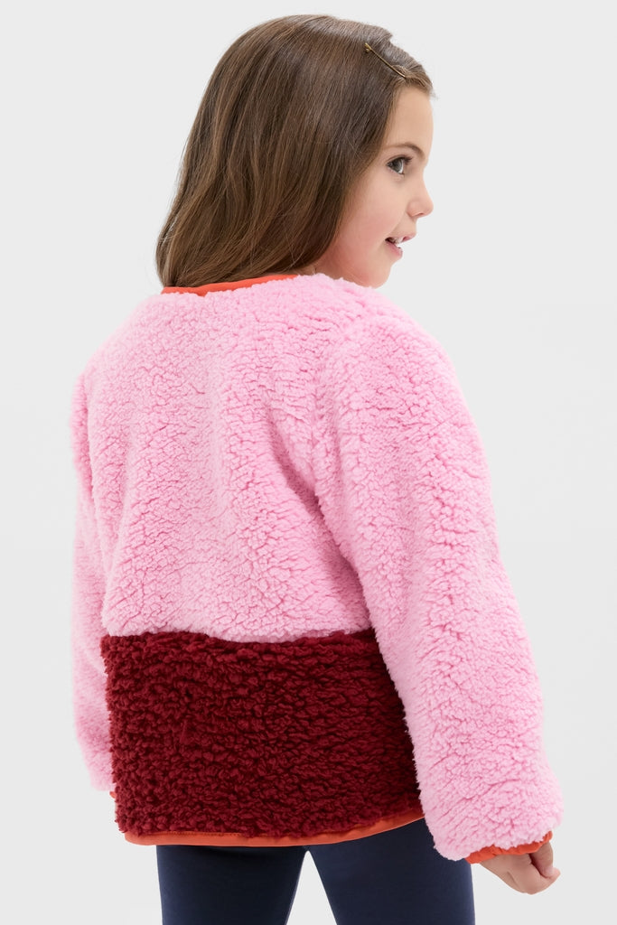 Young girl in Girls Ruth Jacket, a classic two-tone sherpa fleece with effortless style, featuring fun contrast piping and high-end silver glitter buttons.