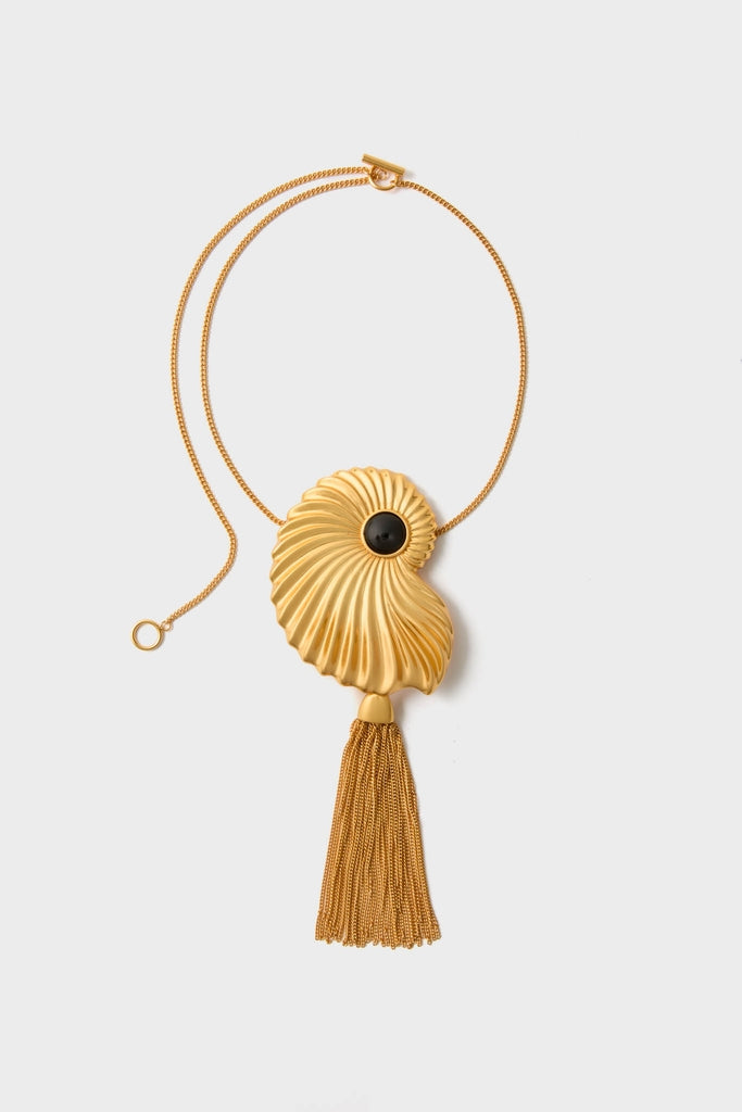 Gold Aveline Necklace features a classic nautilus-shell pendant with a black stone and tassel, embodying effortless, high-end style for fun, confident wear.
