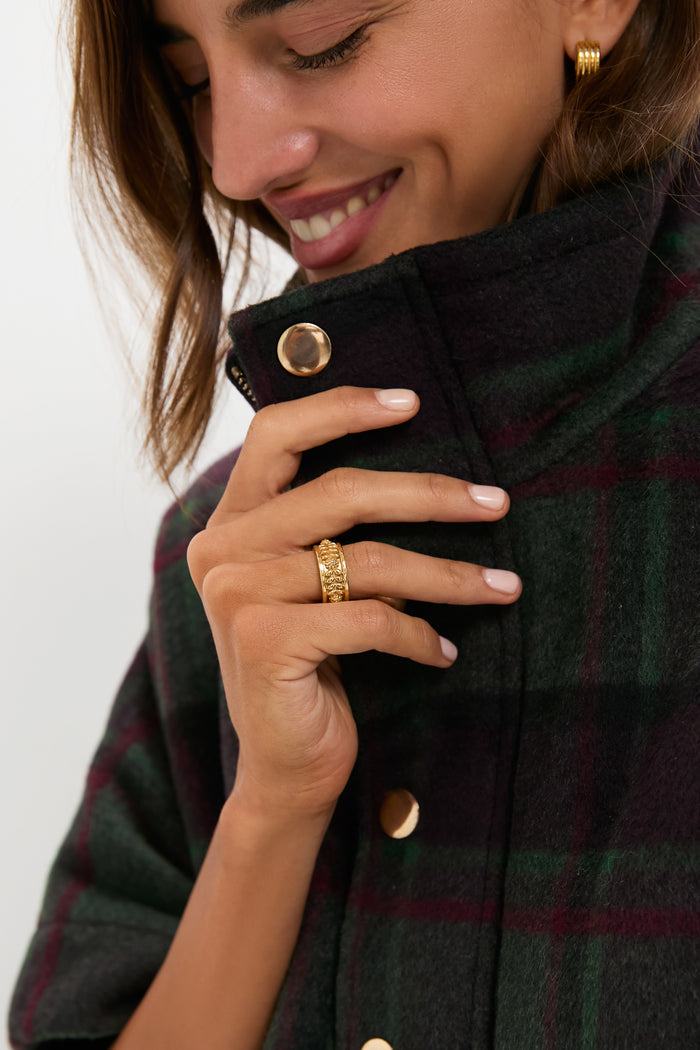Smiling woman wearing a classic dark wool coat, showcasing an effortless Gold Berry Vine Ring with dainty leaves and berries, embodying a high-end, fun aesthetic.