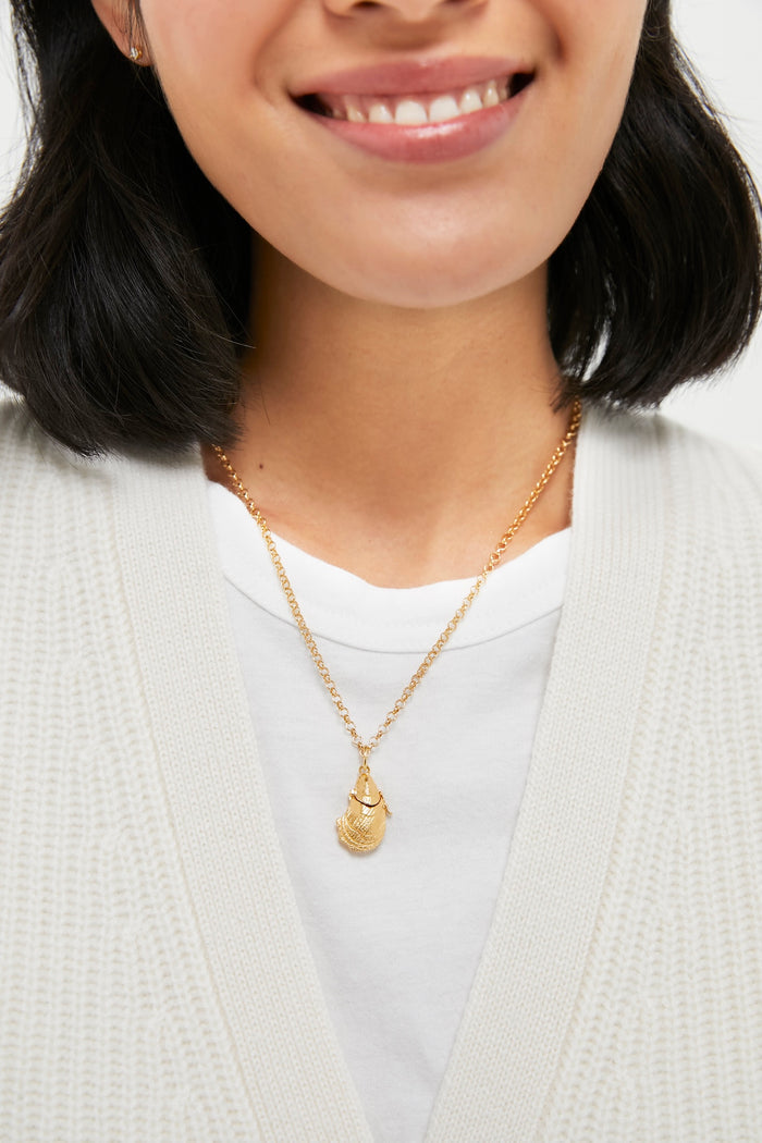 Woman wearing a classic, high-end Gold Oyster Vesta Case 26 Necklace with a textured teardrop pendant, exuding effortless elegance and fun charm.