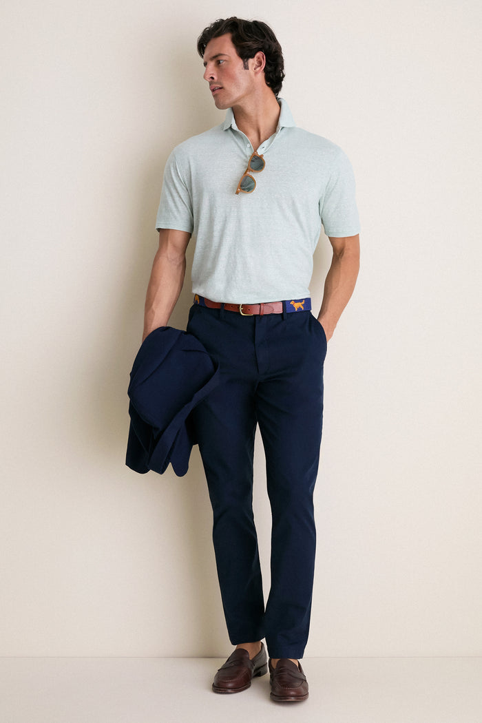Model wearing the Grandview Linen Sanibel Polo, a classic mint-green shirt with an effortless vibe, paired with navy chinos and holding a matching blazer for a high-end look.