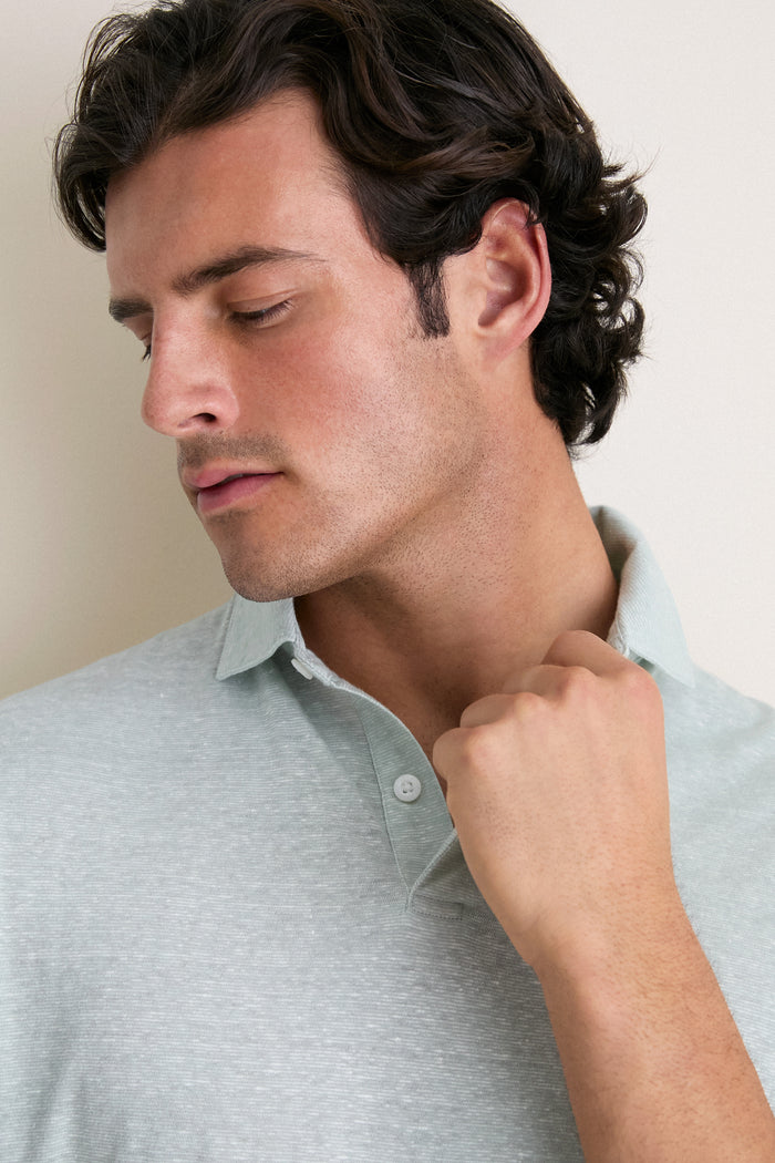 Young man wearing the Grandview Linen Sanibel Polo, a classic, effortless piece with a low-profile collar and partial button placket, embodying fun and high-end style.