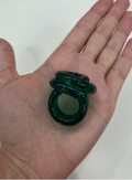 A hand displays three stacked dark green translucent rings from Tuckernuck Vintage Accessories against a plain light background.