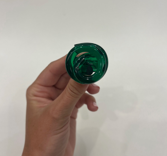 Hand holding a Green Acrylic Swirl Ring, showcasing its classic, translucent spiral design. This effortless, high-end accessory embodies fun and elegance.