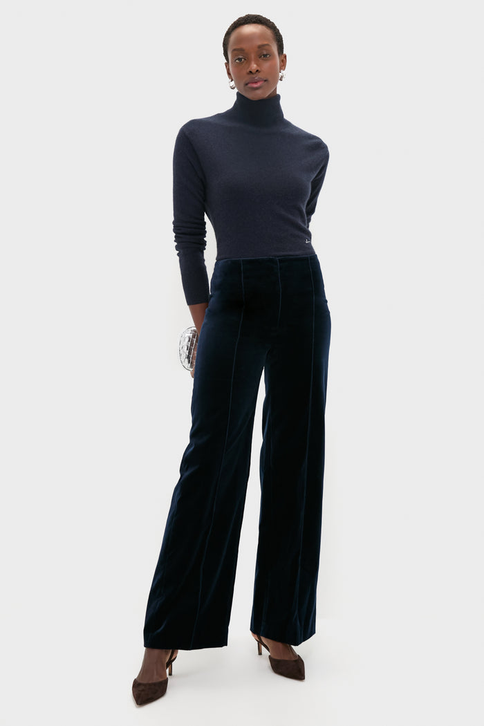 Woman wearing classic High Polish Silver Leona Hoops, effortlessly styled with a navy turtleneck and velvet trousers. The hoops add a fun, high-end touch to her look.