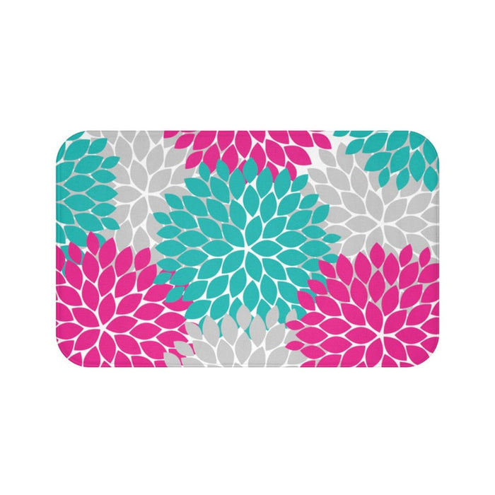 A rectangular memory foam mat with a floral burst design in hot pink, aqua, and gray, featuring an anti-slip backing.