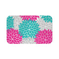A rectangular memory foam mat with a floral burst design in hot pink, aqua, and gray, featuring an anti-slip backing.