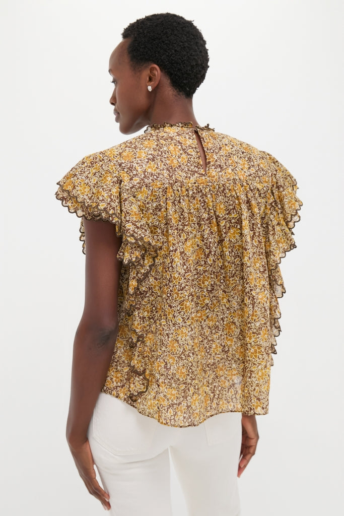 Back view of a woman in the Khaki Daliyane Top, showcasing its classic, effortless elegance with ruffled flutter sleeves and a stylish keyhole detail. Paired with white pants.
