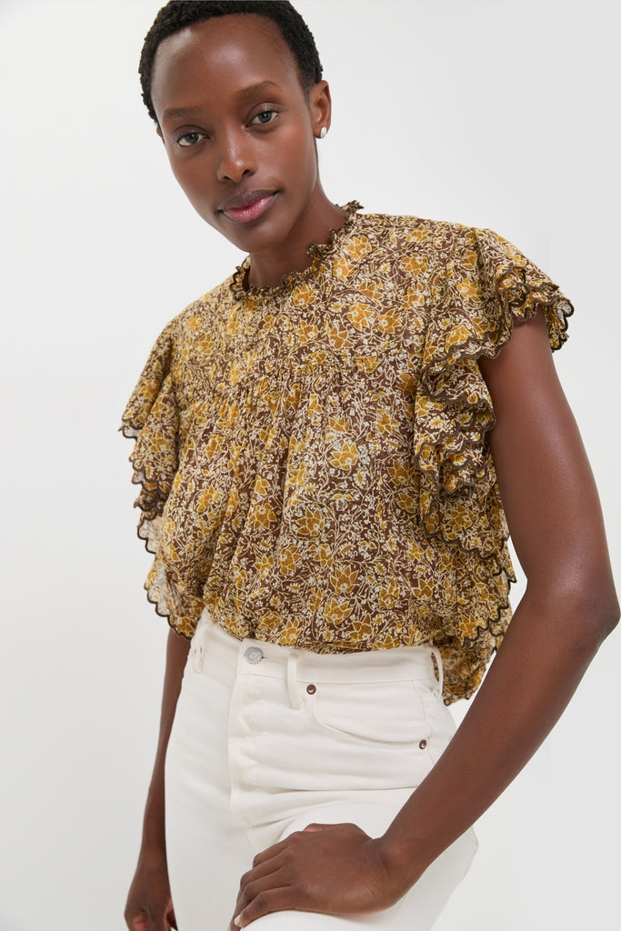 Model wearing the Khaki Daliyane Top, a classic, effortless, high-end blouse with ruffle trim and yellow floral print, paired with fun, high-waisted jeans.
