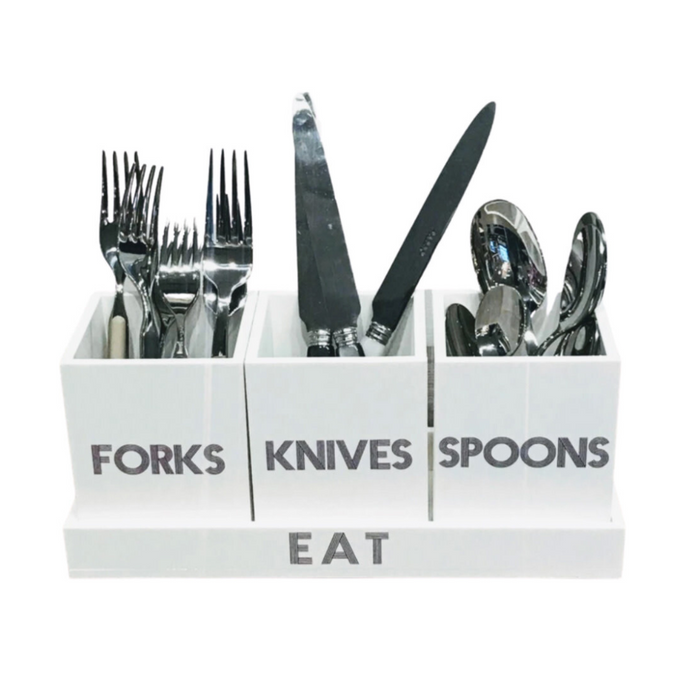 The Eye Candy Let's Eat Silverware Caddy in white with dark grey features three labeled compartments for forks, knives, and spoons, matching silverware inside, and "EAT" printed at the bottom.