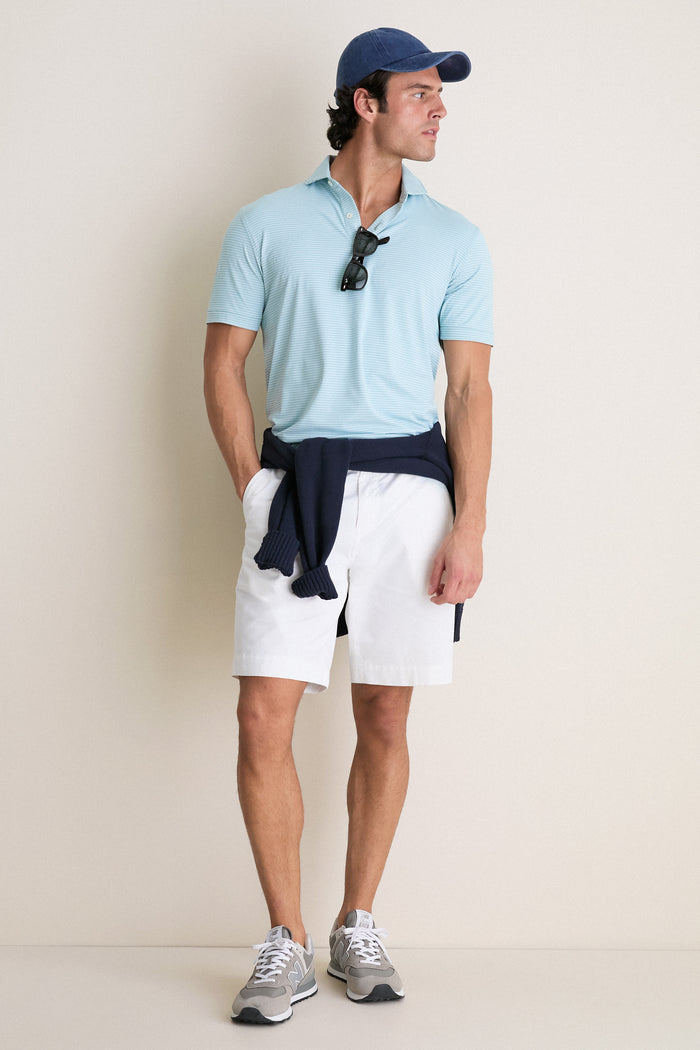 Man wearing the Light Willow Ballad Performance Jersey Polo, showcasing its classic style and effortless fit. He embodies a high-end, fun look with tailored shorts and accessories.