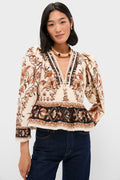 Model wearing the Majestic Garden Sand Blouse, a classic, effortless peplum-style top with a floral paisley print, deep V-neck, and puffed sleeves, paired with high-waisted jeans.