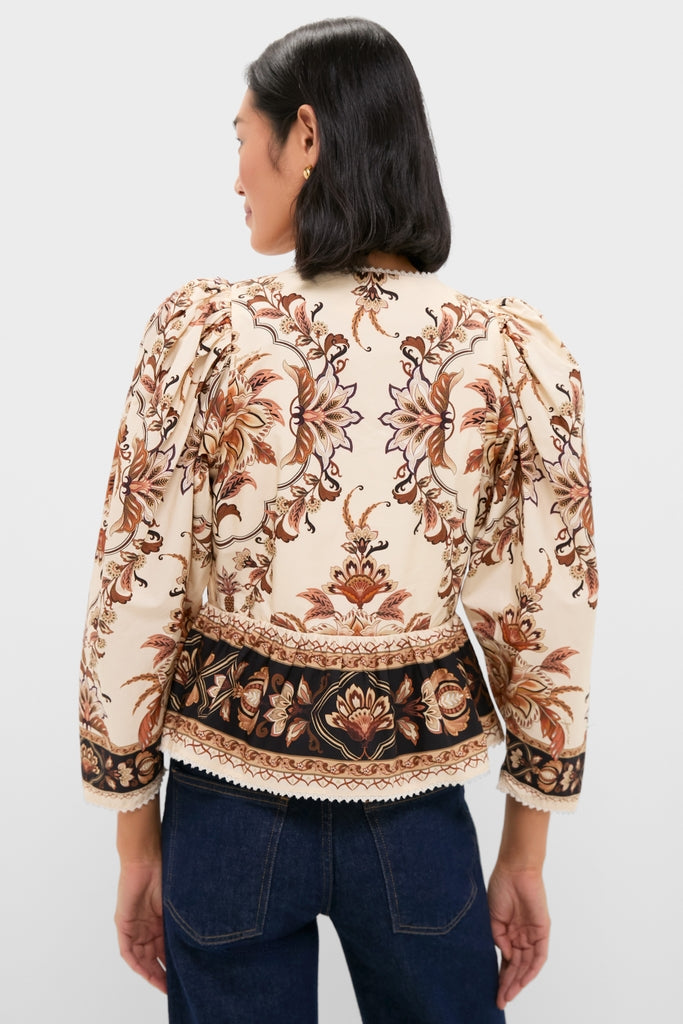 Majestic Garden Sand Blouse with intricate floral print, peplum waist, and darker hem, embodies effortless, classic style paired with dark blue jeans for a fun, high-end look.